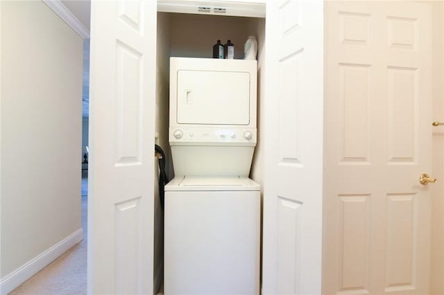 200 Roger Williams Ave Unit 106, East Providence, RI 02916 - laundry room featuring estacked washer and dryer, baseboards, crown molding, and light colored carpet