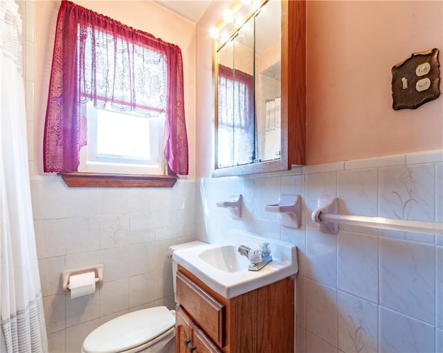 49 Gooding St, Pawtucket, RI 02860 - bathroom featuring toilet, vanity, tile walls, and a wainscoted wall