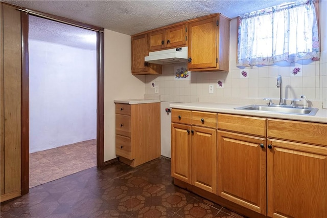 49 Gooding St, Pawtucket, RI 02860 - kitchen with under cabinet range hood, a sink, brown cabinets, light countertops, and dark floors