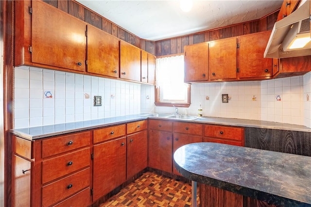 49 Gooding St, Pawtucket, RI 02860 - kitchen with a sink, under cabinet range hood, backsplash, and brown cabinets
