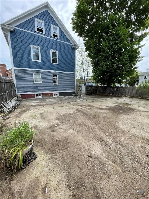 rear view of property featuring fence