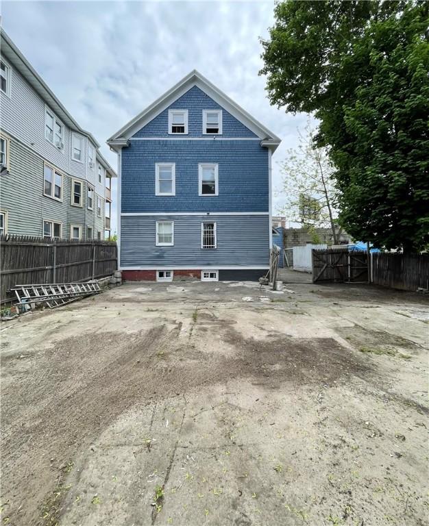 rear view of house with fence and brick siding