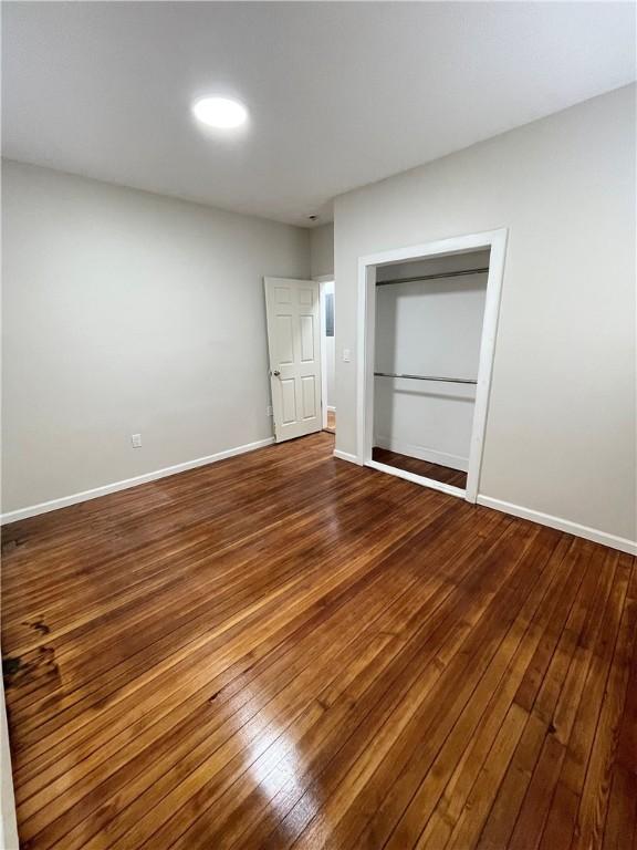 unfurnished room featuring hardwood / wood-style floors and baseboards