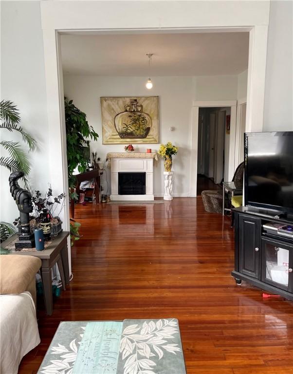 living area featuring wood finished floors and a fireplace with raised hearth