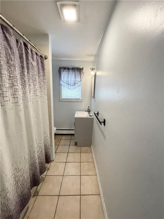 full bathroom featuring baseboard heating, tile patterned floors, toilet, baseboards, and vanity