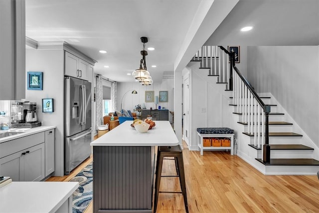 1 Fried Ave, Bristol, RI 02809 - kitchen with stainless steel fridge with ice dispenser, gray cabinetry, light wood finished floors, a kitchen bar, and recessed lighting