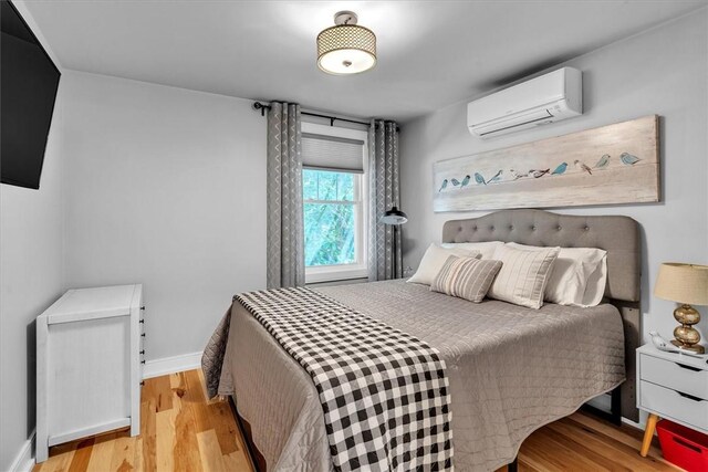 1 Fried Ave, Bristol, RI 02809 - bedroom featuring a wall mounted air conditioner, wood finished floors, and baseboards