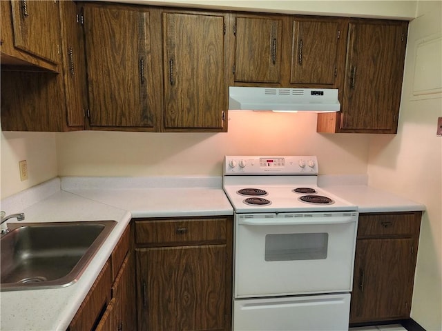 29 School St Unit 12E, Westerly, RI 02891 - kitchen with under cabinet range hood, white range with electric stovetop, a sink, light countertops, and dark brown cabinets