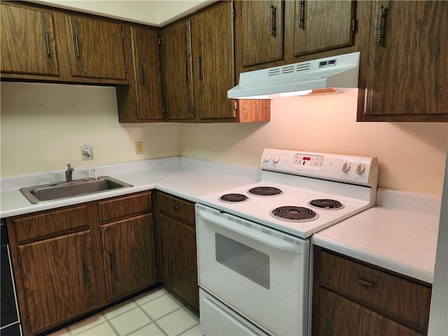 29 School St Unit 12E, Westerly, RI 02891 - kitchen with under cabinet range hood, white range with electric cooktop, a sink, light countertops, and dark brown cabinetry
