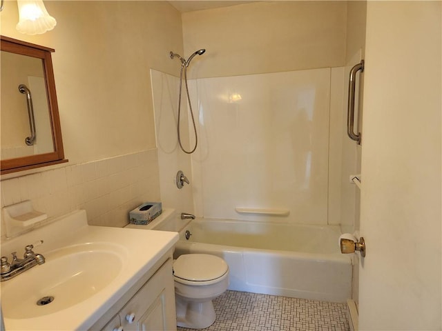 29 School St Unit 12E, Westerly, RI 02891 - bathroom with washtub / shower combination, toilet, vanity, tile patterned flooring, and tile walls