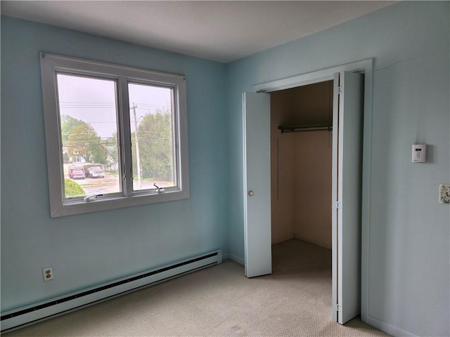 29 School St Unit 12E, Westerly, RI 02891 - unfurnished bedroom featuring a baseboard radiator, multiple windows, light carpet, and a closet
