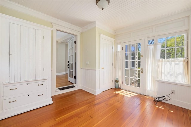 110 Narragansett Ave W, South Kingstown, RI 02879 - doorway with light wood-style floors, crown molding, a decorative wall, and a wainscoted wall
