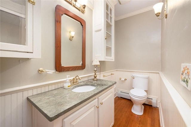 110 Narragansett Ave W, South Kingstown, RI 02879 - bathroom with a baseboard radiator, a wainscoted wall, ornamental molding, toilet, and wood finished floors