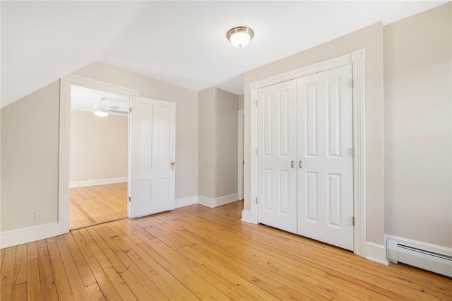 110 Narragansett Ave W, South Kingstown, RI 02879 - unfurnished bedroom with baseboard heating, light wood finished floors, a closet, baseboards, and lofted ceiling