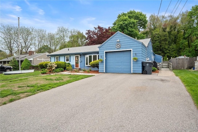 ranch-style home featuring asphalt driveway, a garage, a shingled roof, and a gate