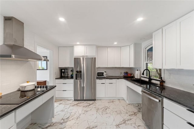 kitchen featuring stainless steel appliances, wall chimney exhaust hood, a sink, healthy amount of natural light, and recessed lighting