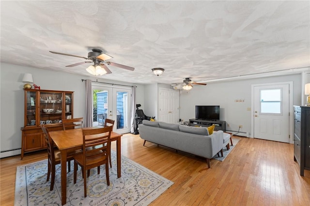 dining room with a ceiling fan, a baseboard heating unit, plenty of natural light, and french doors