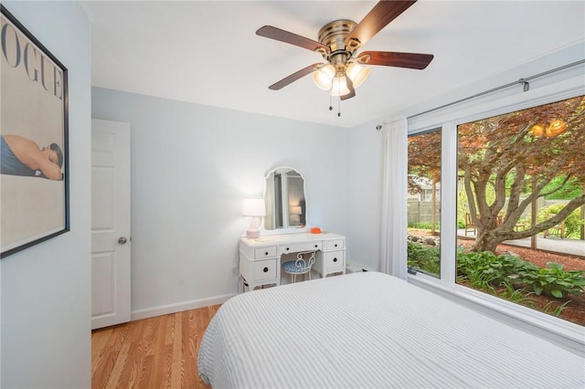 bedroom featuring light wood-style flooring, baseboards, and ceiling fan