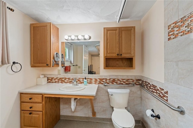 half bathroom with a sink, toilet, and tile walls