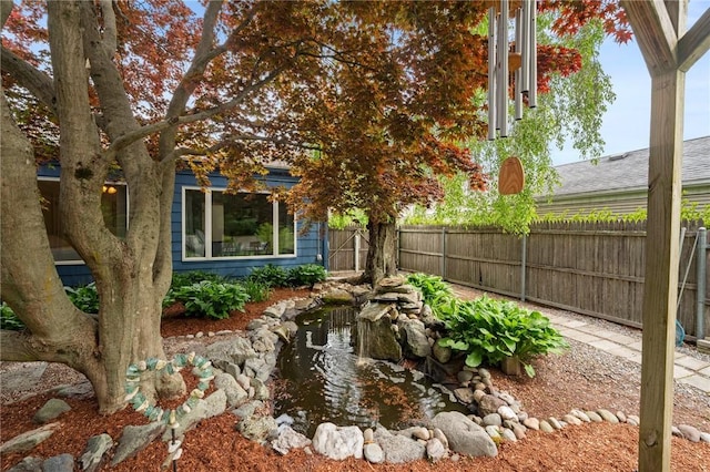 view of yard with fence and a small pond