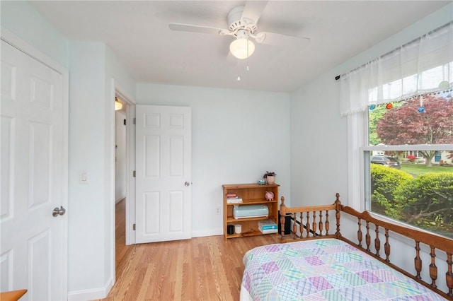 bedroom featuring light wood finished floors, baseboards, and ceiling fan