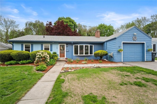 ranch-style house featuring an attached garage, a front lawn, a chimney, and driveway