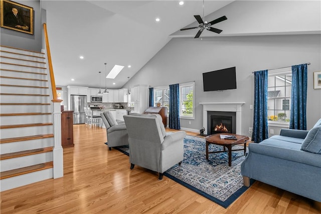 9 Thelma Ln, Middletown, RI 02842 - living area with high vaulted ceiling, light wood-style floors, recessed lighting, stairway, and a glass covered fireplace