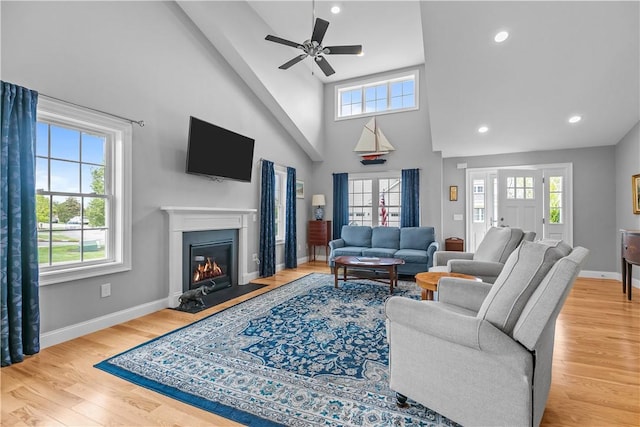 9 Thelma Ln, Middletown, RI 02842 - living room featuring healthy amount of natural light, high vaulted ceiling, a glass covered fireplace, a ceiling fan, and baseboards