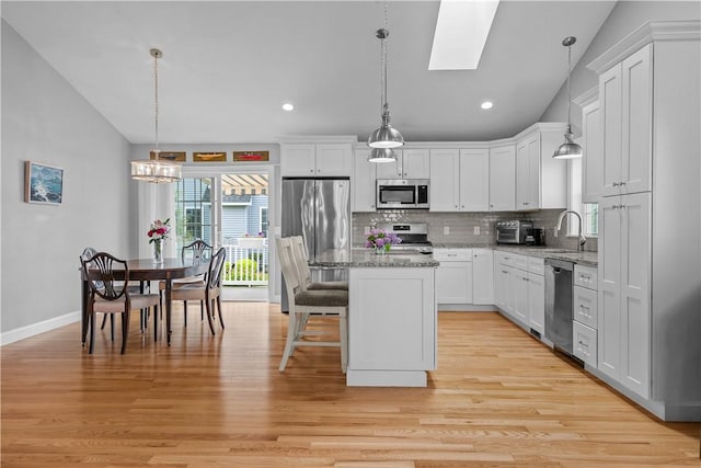 9 Thelma Ln, Middletown, RI 02842 - kitchen featuring stainless steel appliances, vaulted ceiling, backsplash, white cabinets, and recessed lighting