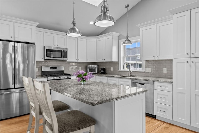 9 Thelma Ln, Middletown, RI 02842 - kitchen featuring appliances with stainless steel finishes, a sink, white cabinetry, a kitchen island, and lofted ceiling