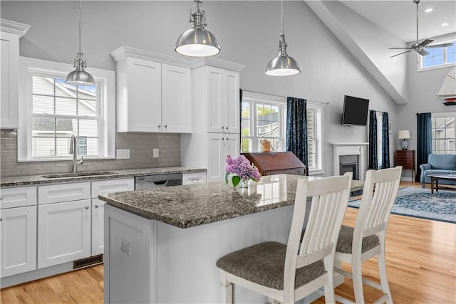 9 Thelma Ln, Middletown, RI 02842 - kitchen featuring a sink, open floor plan, light wood-style floors, dishwasher, and white cabinetry