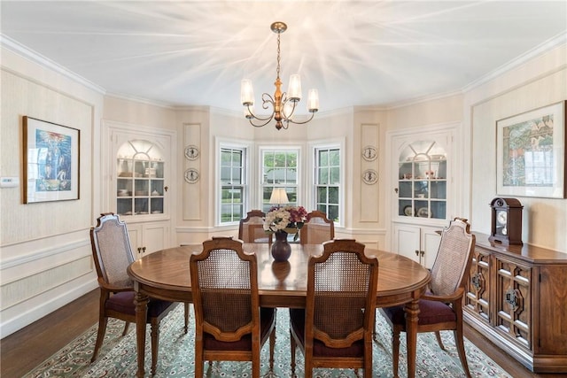 dining room featuring a chandelier, wood finished floors, a decorative wall, and ornamental molding