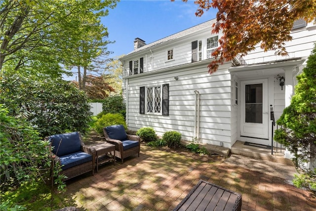 back of property with a chimney, an outdoor hangout area, and a wooden deck