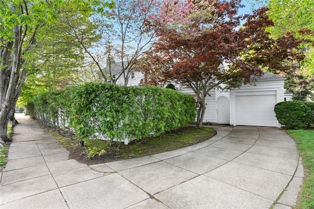 view of side of property featuring concrete driveway