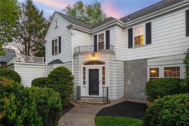 view of front of house featuring a balcony and stone siding