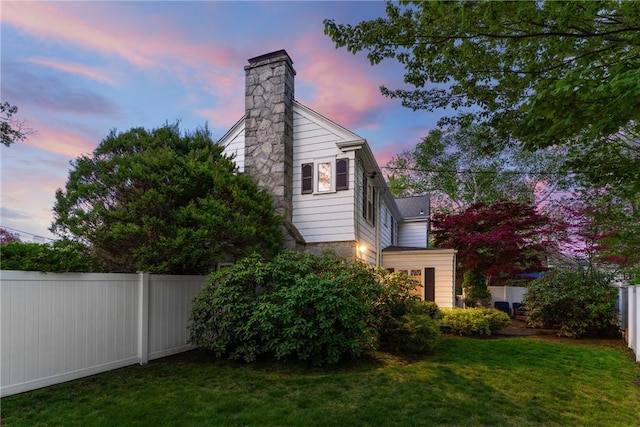 property exterior at dusk featuring a chimney