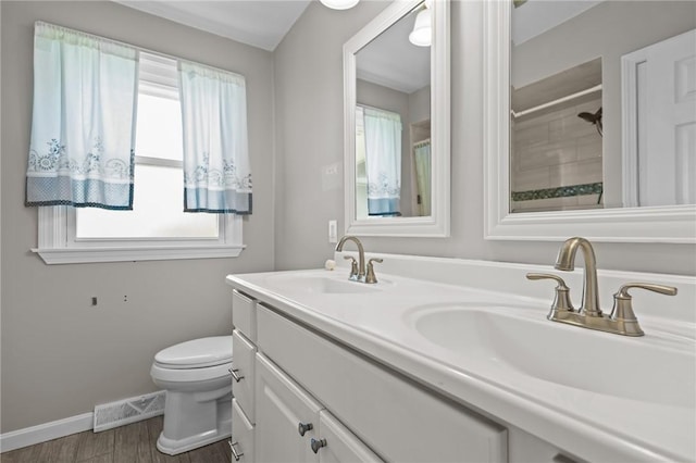 bathroom featuring baseboards, toilet, wood finished floors, double vanity, and a shower with curtain