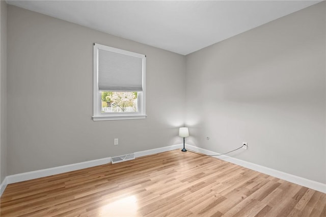 spare room featuring light wood-style flooring and baseboards