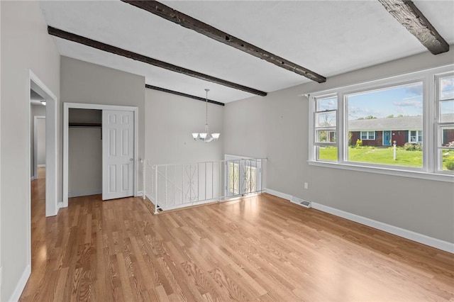 unfurnished room featuring beamed ceiling, a chandelier, light wood-style flooring, and baseboards