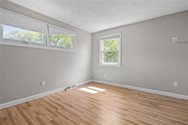 empty room with baseboards and light wood-style floors