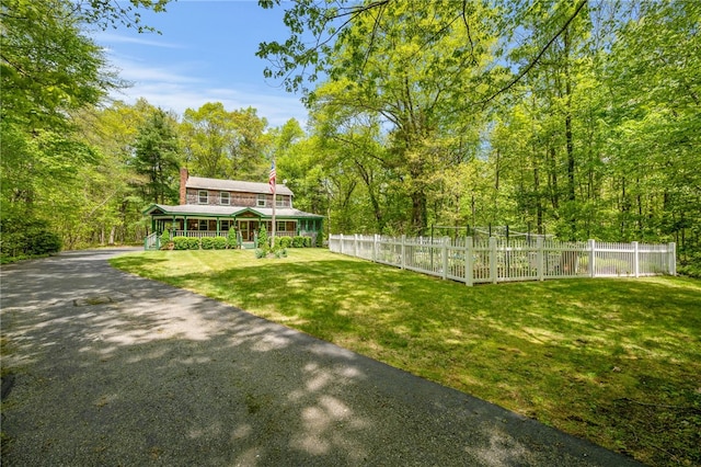 view of yard featuring covered porch and a wooded view