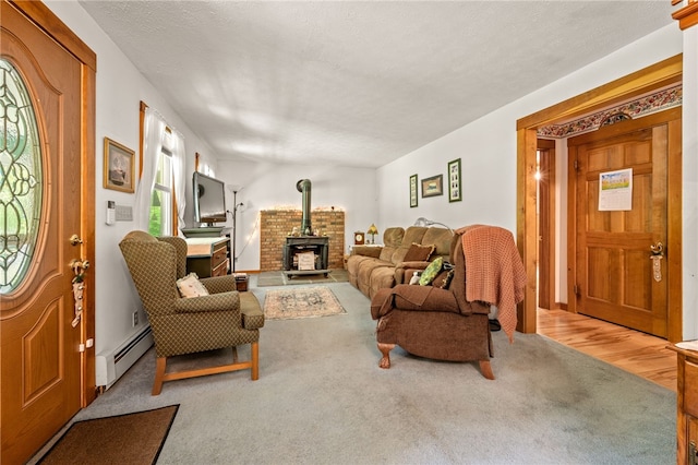 carpeted living room with baseboard heating and a wood stove
