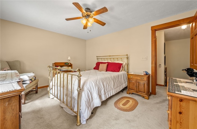 bedroom with light colored carpet, baseboards, and a ceiling fan
