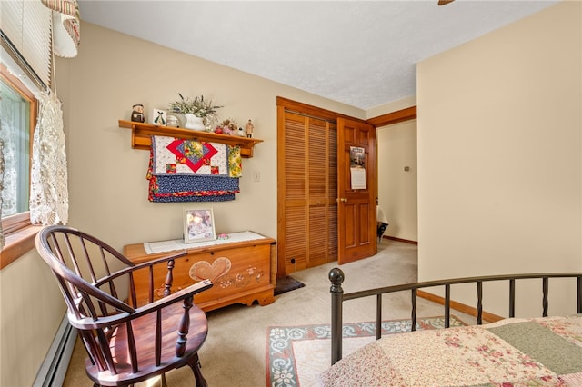 carpeted bedroom with a baseboard heating unit and a closet
