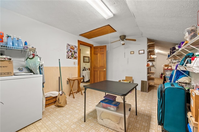 rec room with washer / clothes dryer, a ceiling fan, a textured ceiling, a wainscoted wall, and vaulted ceiling