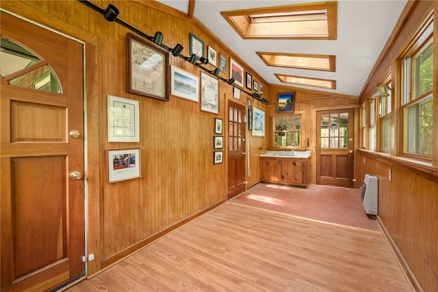 unfurnished sunroom featuring heating unit and a skylight