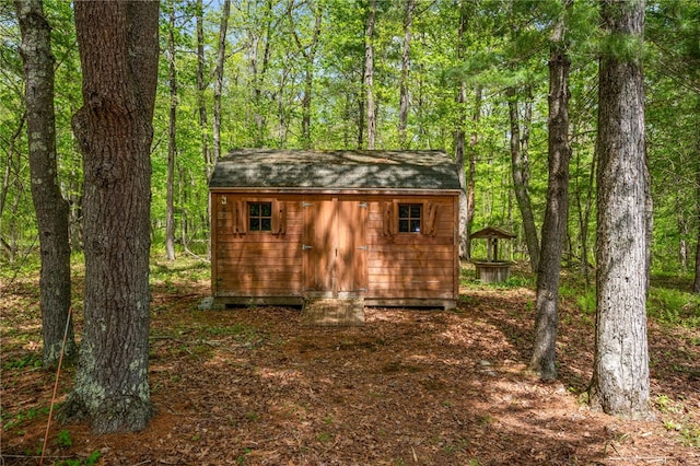 view of shed featuring a view of trees