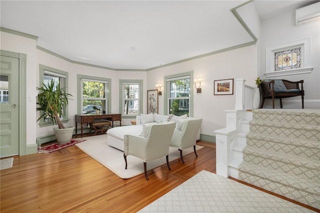 3 Hidden St, Providence, RI 02906 - living area featuring a wall mounted AC, wood finished floors, a baseboard radiator, crown molding, and stairway