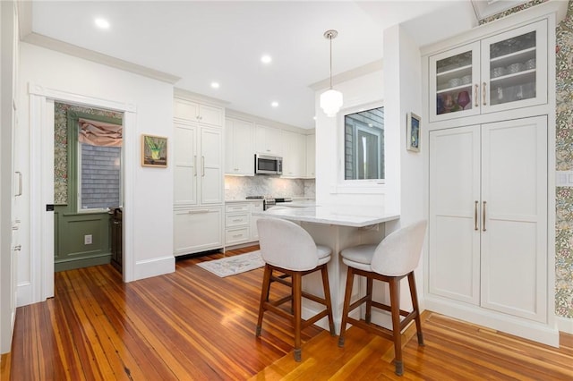 3 Hidden St, Providence, RI 02906 - kitchen featuring stainless steel microwave, dark wood-style floors, white cabinetry, a peninsula, and recessed lighting