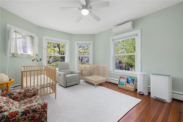 3 Hidden St, Providence, RI 02906 - bedroom with an AC wall unit, multiple windows, hardwood / wood-style floors, and a baseboard heating unit